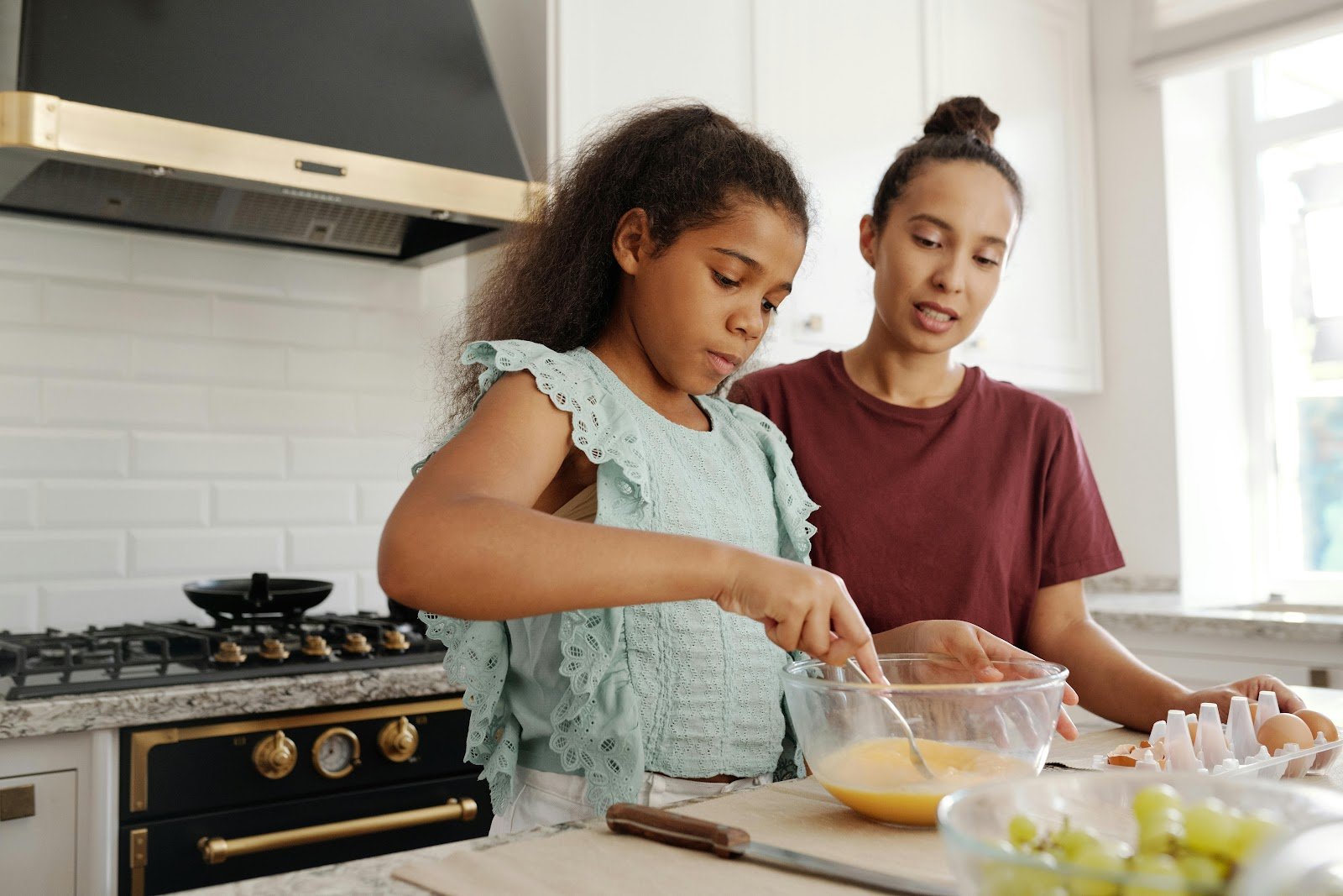 Children cooking with kids, mixing ingredients for the pilchard fish cakes recipe as part of homeschooling activities South Africa