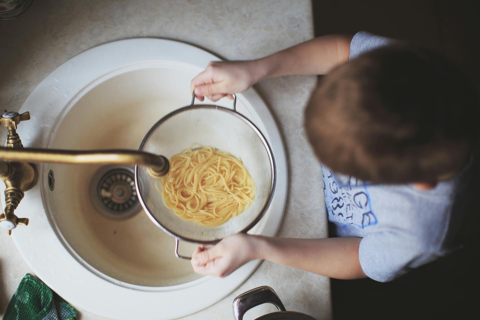 Kids engaged in cooking pasta, a fun homeschooling South Africa activity demonstrating cooking with kids